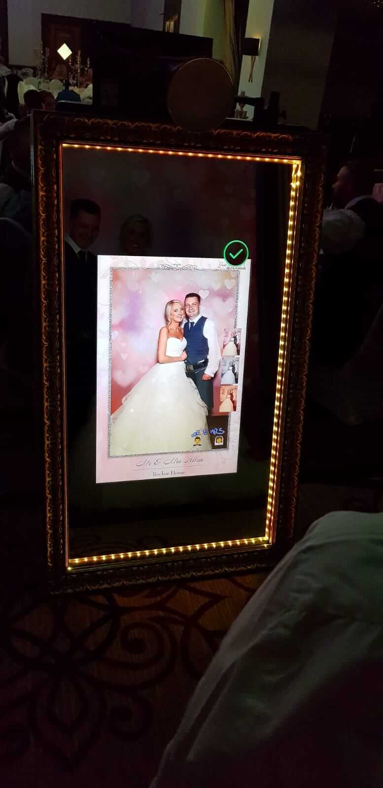 Happily married couple posing for Just A-Pose selfie mirror showing on the mirror screen