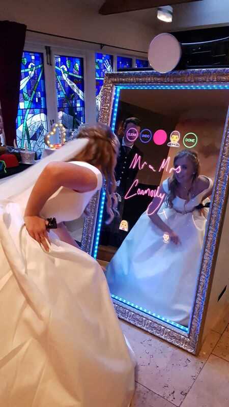Bride signing selfie mirror with her reflection in the mirror.